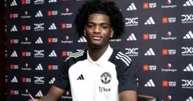 Ayden Heaven poses in a Manchester United shirt after completing his transfer from Arsenal. The defender has signed until 2029.